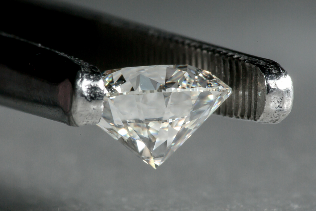 A cut diamond carefully being held ready for grading, Wellington Jewellery Valuations.